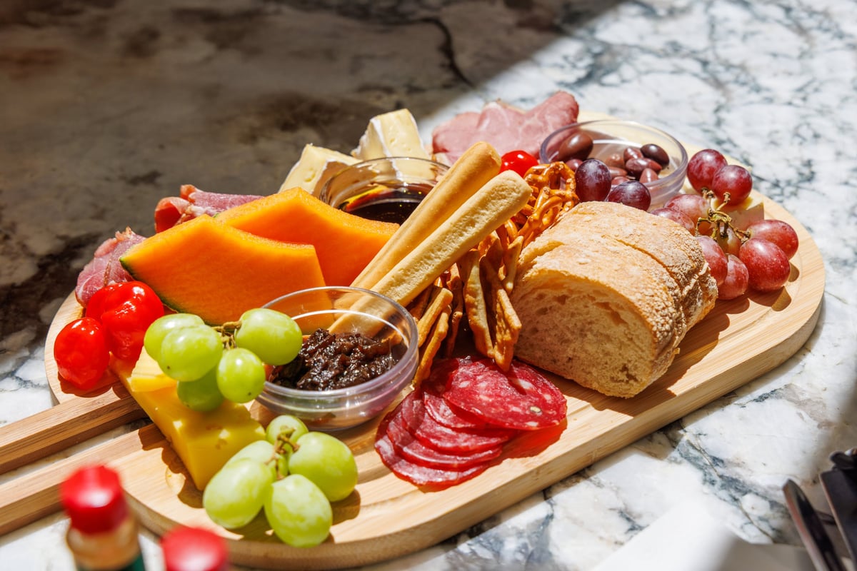 Charcuterie board served on an outdoor table with wine at golden hour